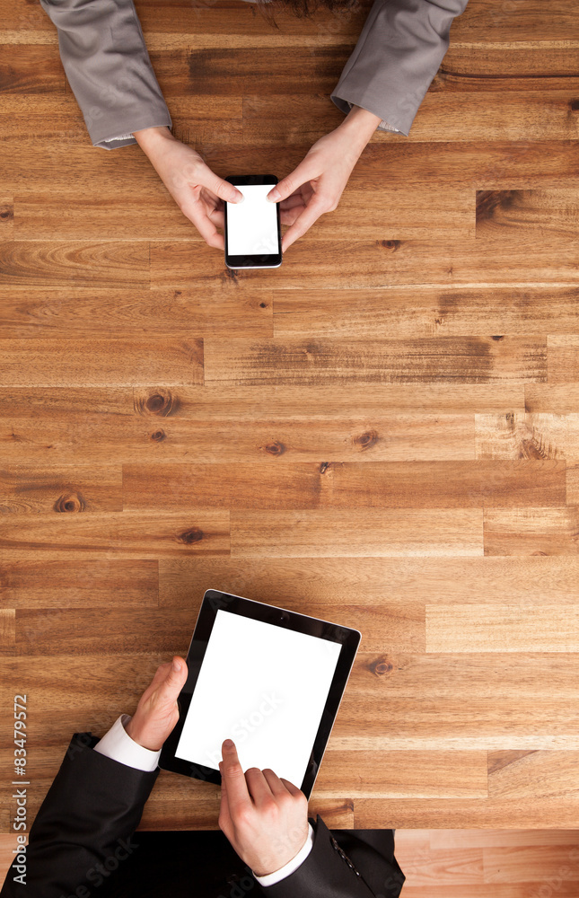 Man and woman working on smart phone and tablet