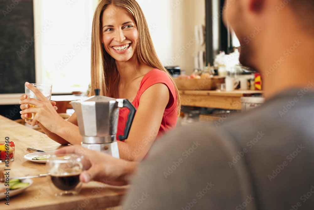 Happy young couple in the kitchen having breakfast