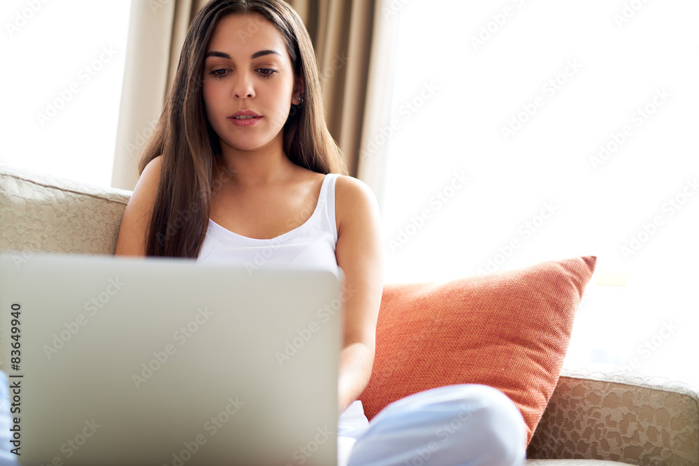 Pretty young woman relaxing with her laptop