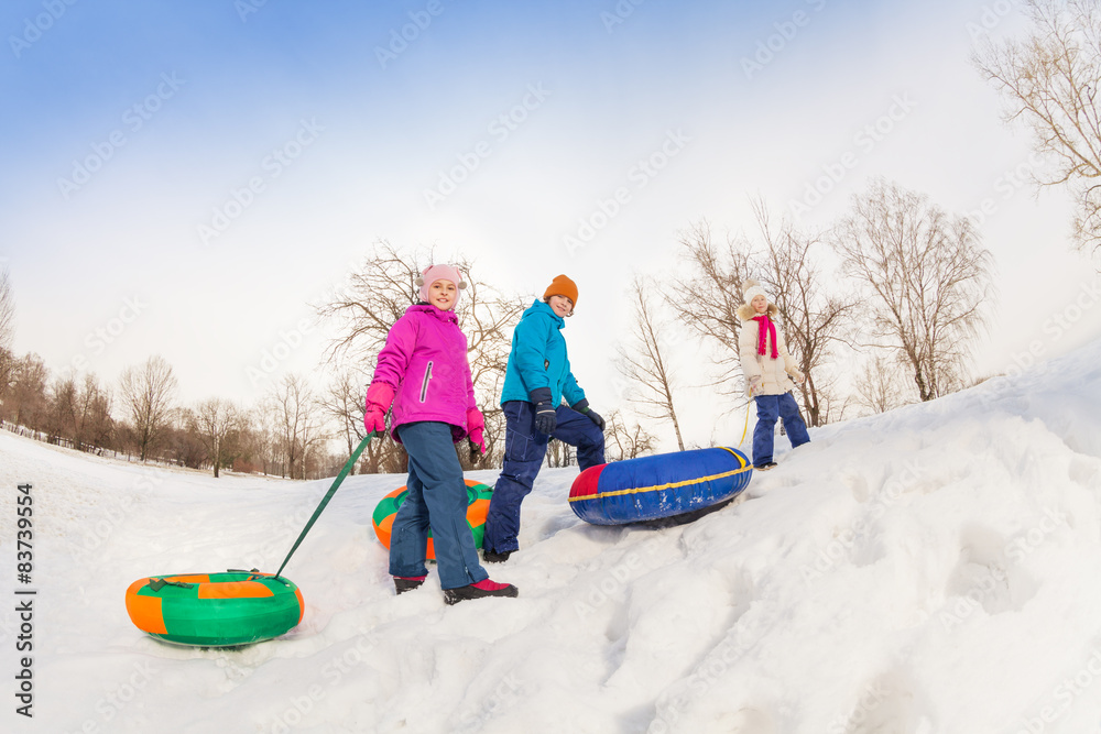 孩子们带着五颜六色的管子走上雪山