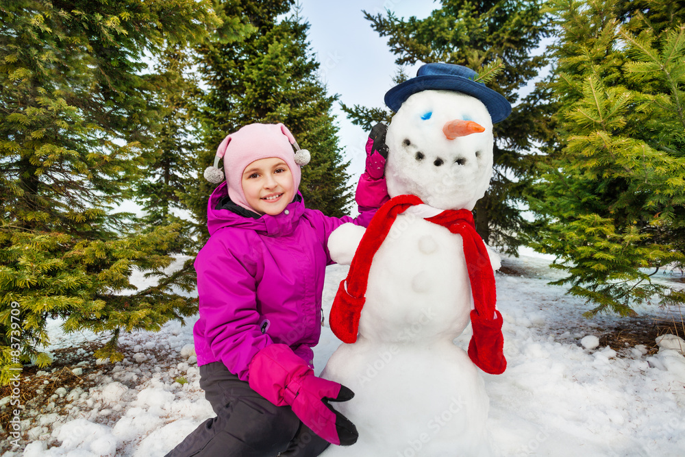 Beautiful girl and cute snowman with red scarf