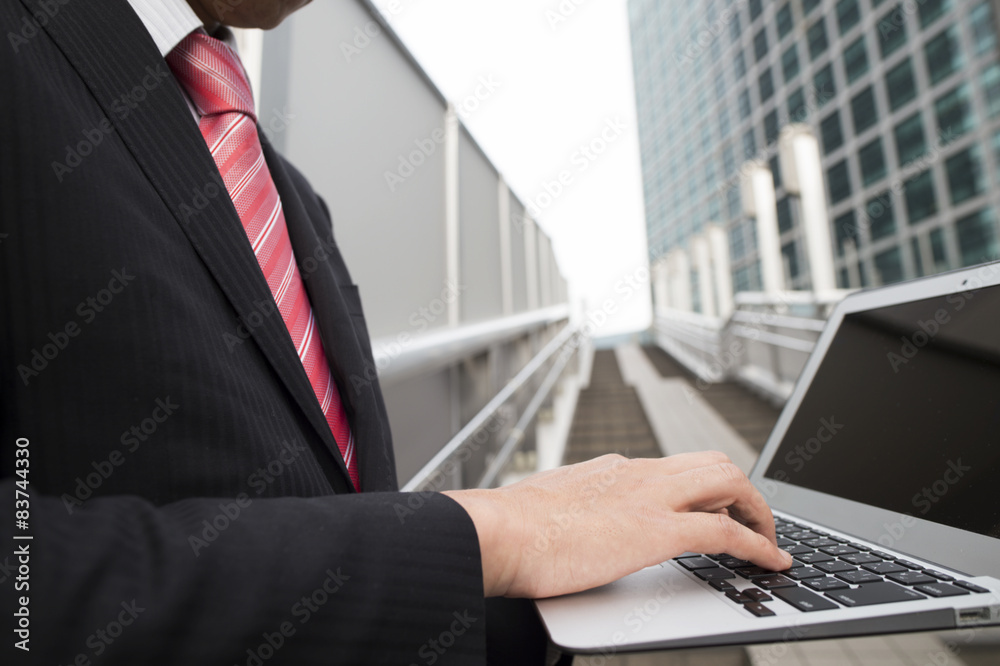 Men open a laptop on the stairs