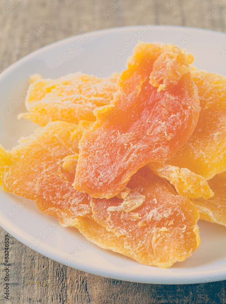 Piece of Dehydrated mango on white ceramic dish