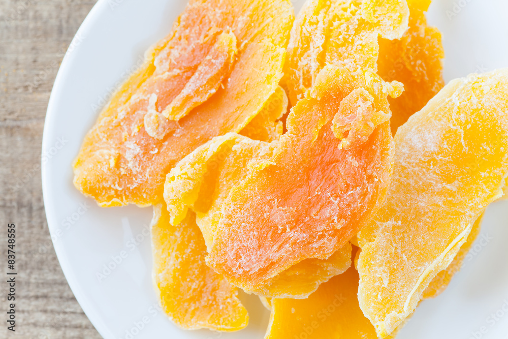 Piece of Dehydrated mango on white ceramic dish