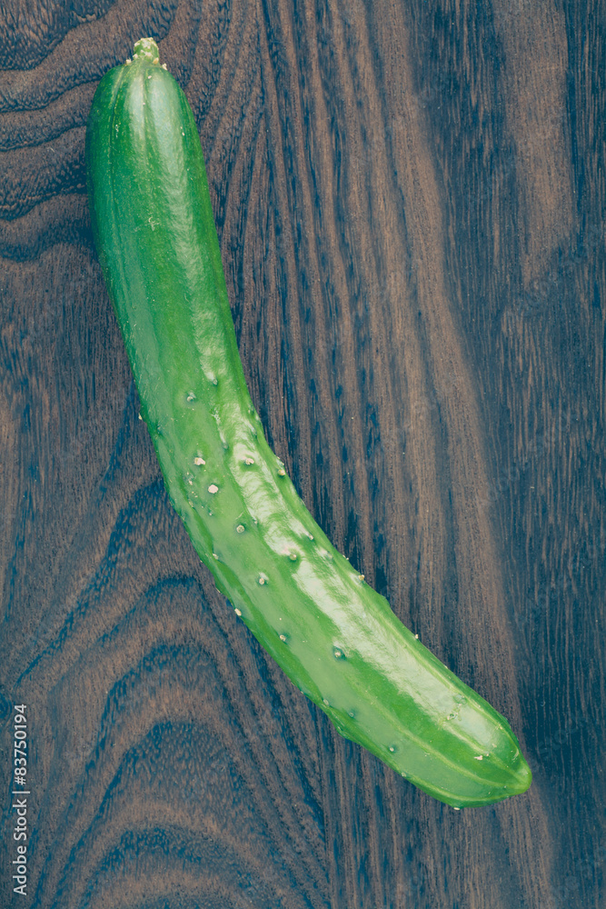 Fresh green cucumber on brown wood background