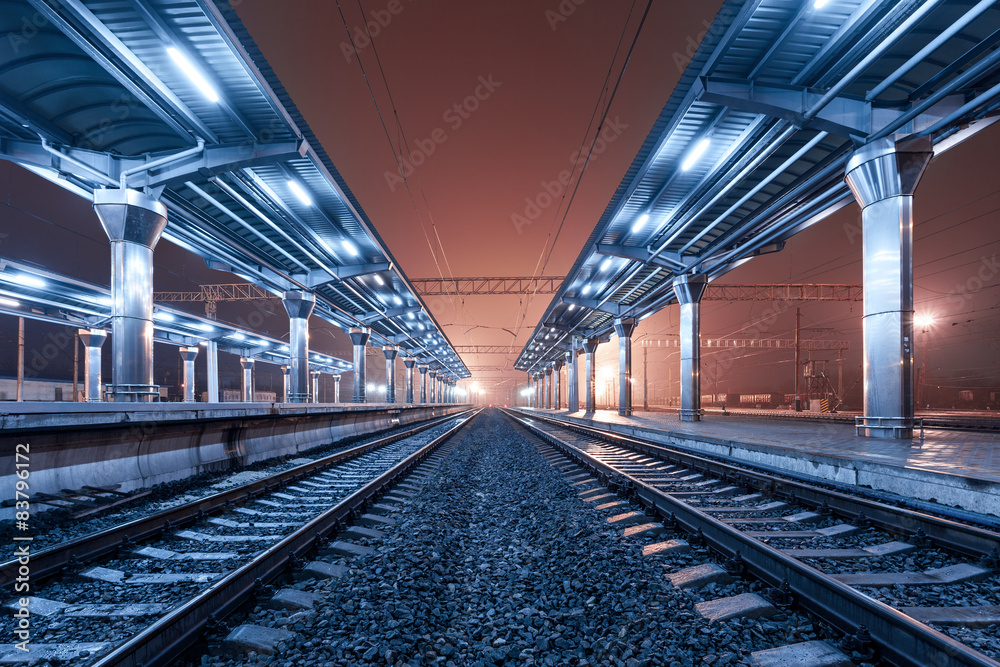 Railway station at night. Train platform in fog. Railroad