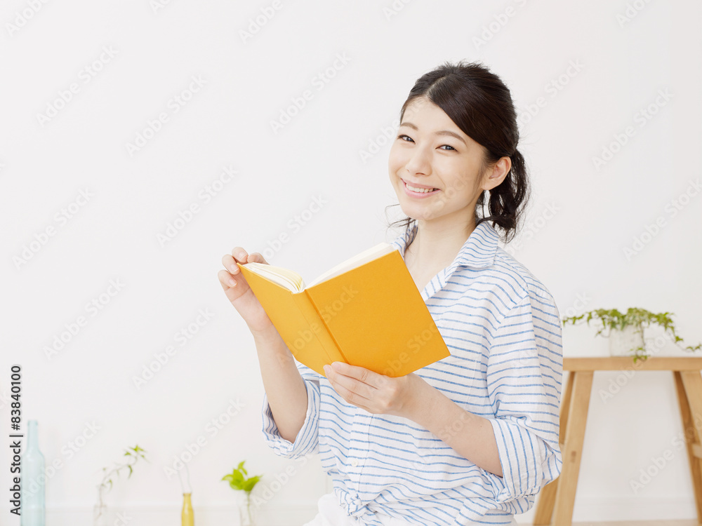 部屋で本を読む女性