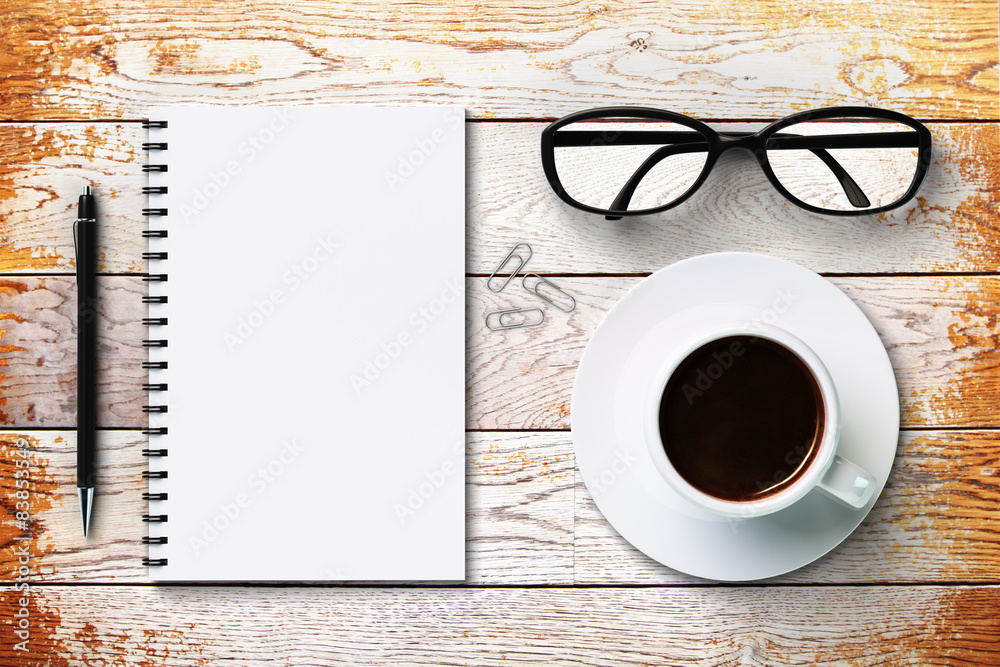 Blank diary and coffee cup on a vintage wooden surface