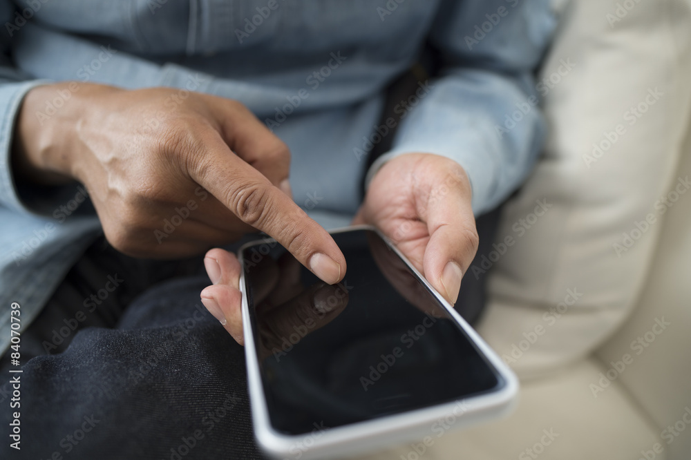 Men are using the latest smart phone sitting on the sofa