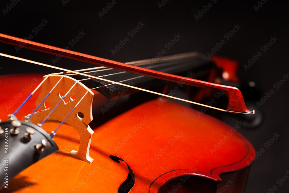 Violoncello with bow stick on black background