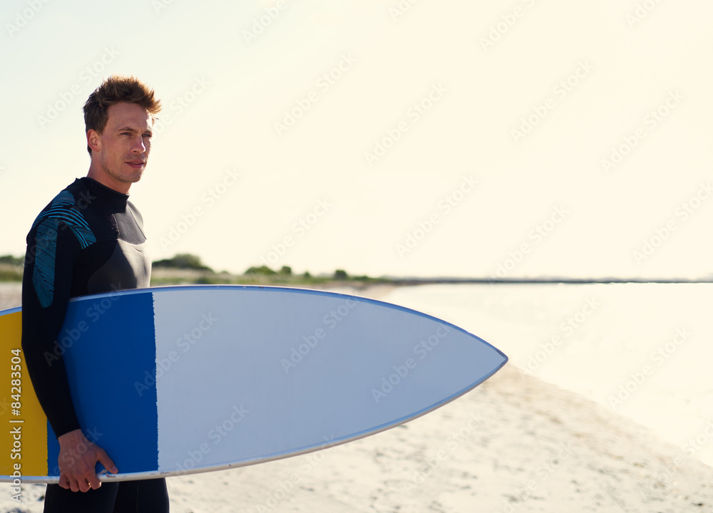 Surfer standing on a tropical beach