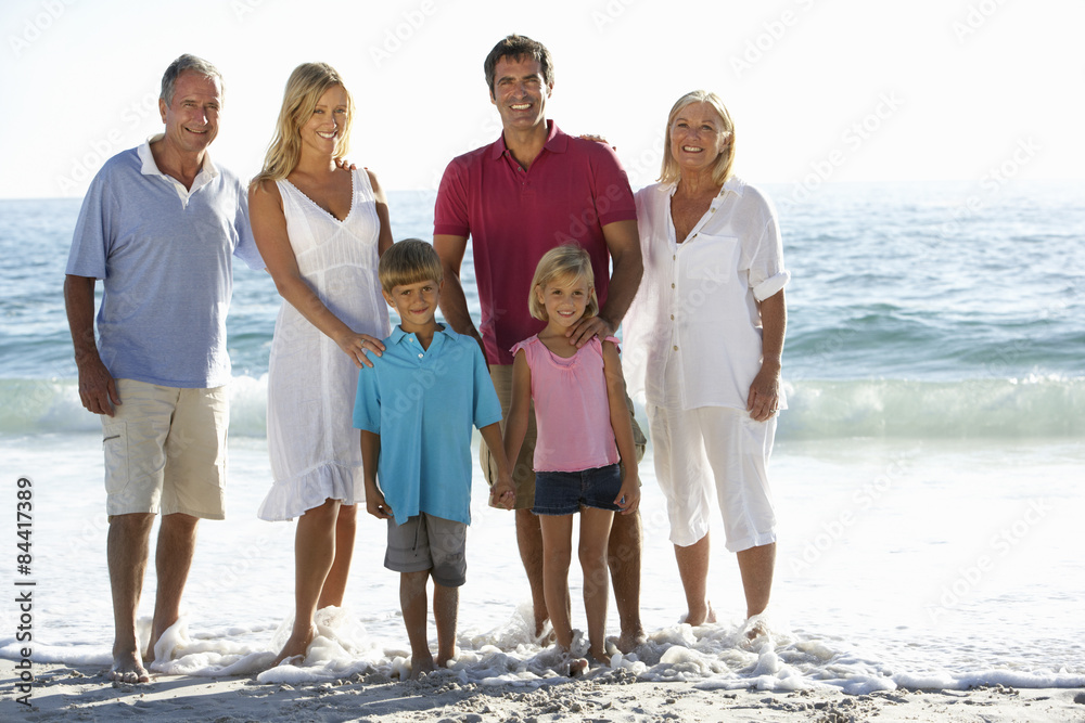 Three Generation Family On Holiday Walking On Beach