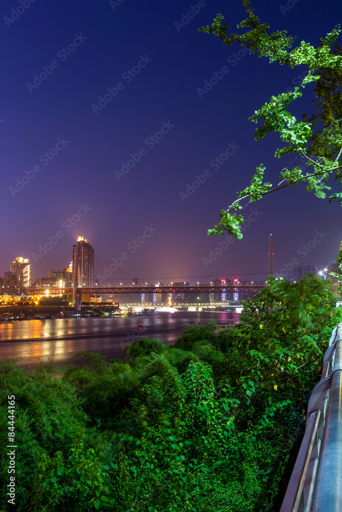 illuminated skyline of chongqing at riverbank