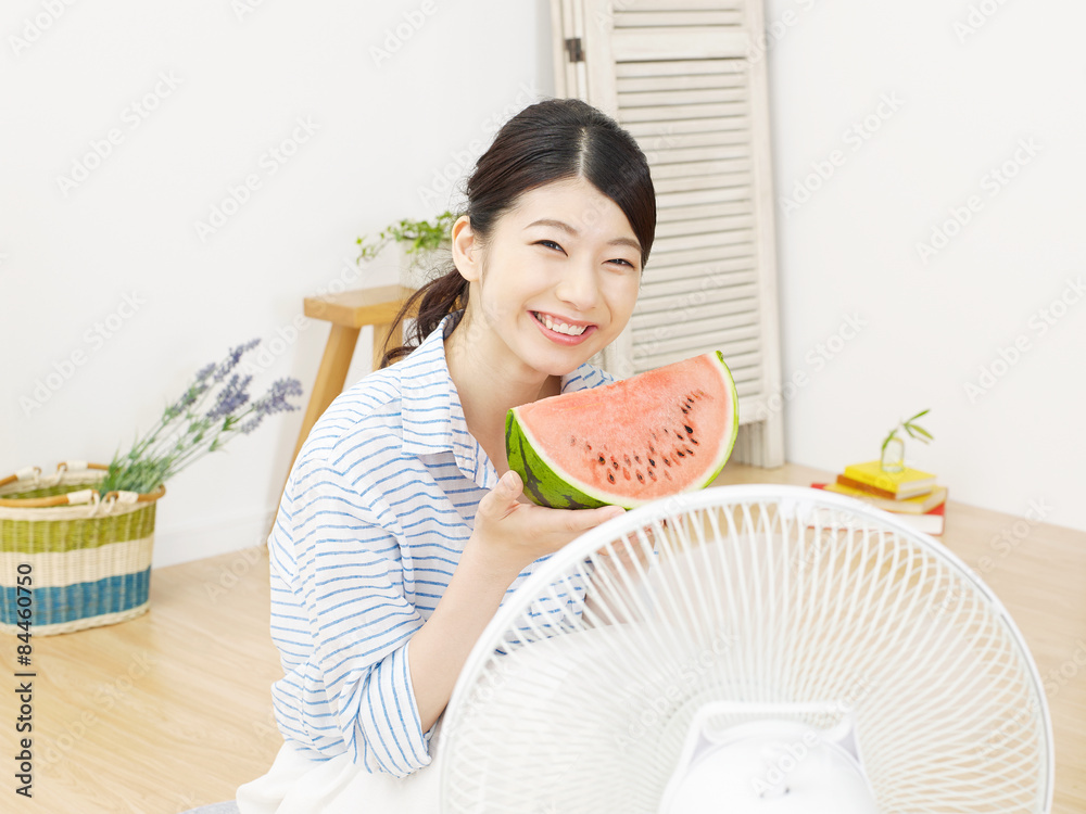 部屋で西瓜を食べる女性