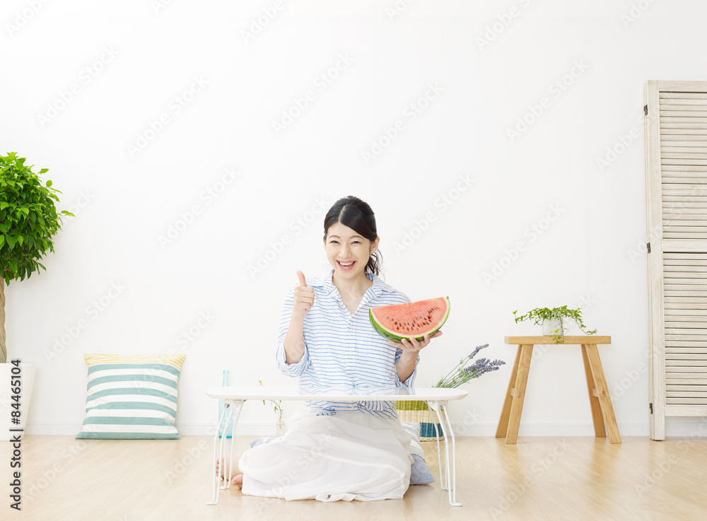 部屋で西瓜を食べる女性