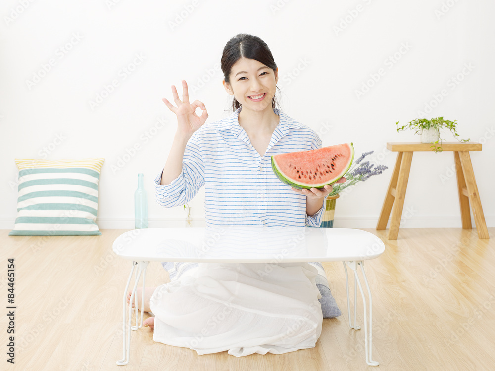 部屋で西瓜を食べる女性