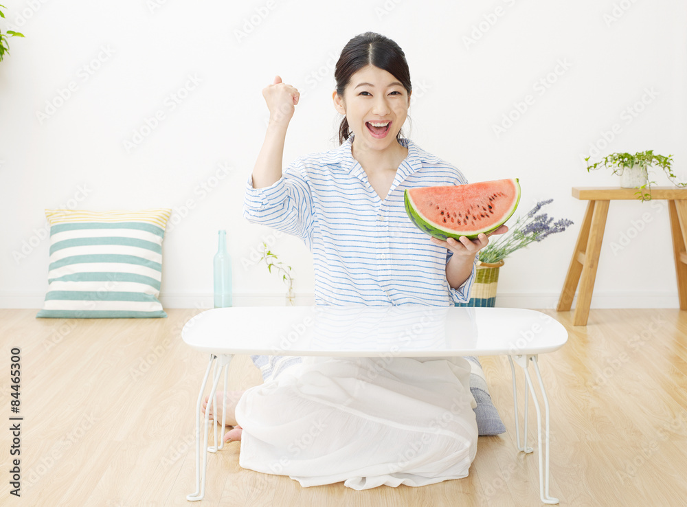 部屋で西瓜を食べる女性