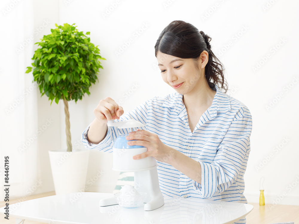 部屋でかき氷をする女性