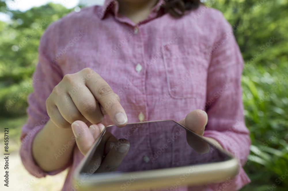 Women who have a mobile game in the park