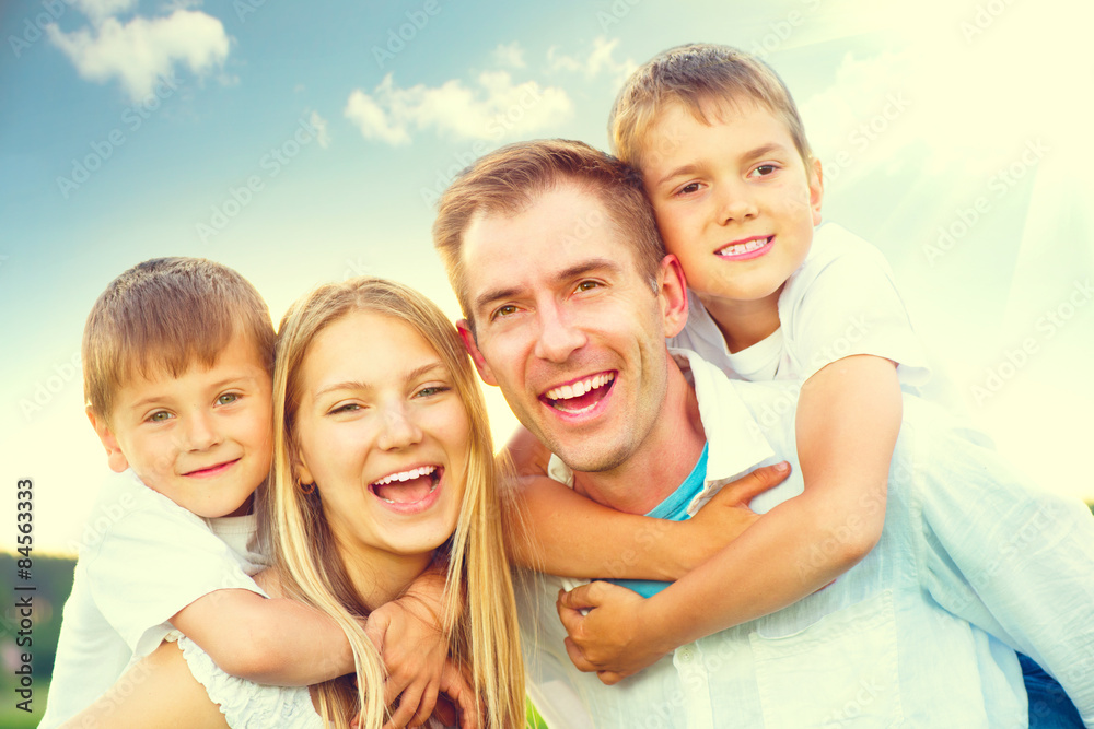 Happy joyful young family having fun in summer park