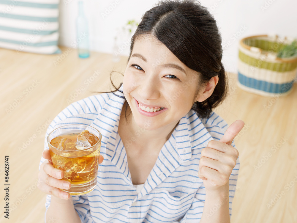 部屋でアイスティーを飲む女性