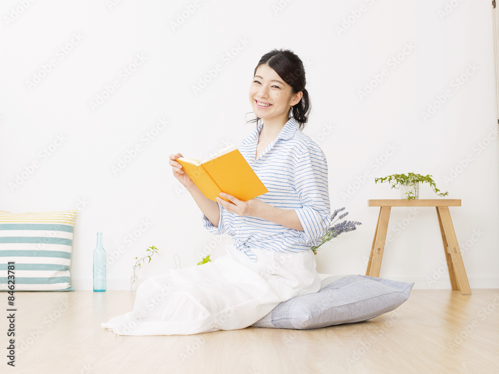 部屋で本を読む女性