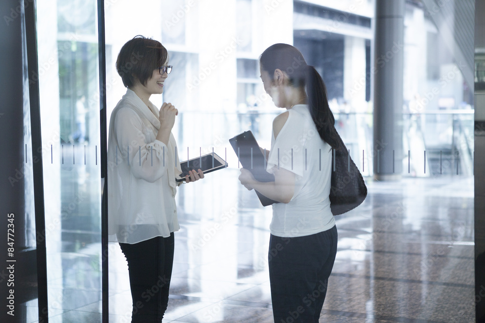 女人在玻璃墙建筑里聊天