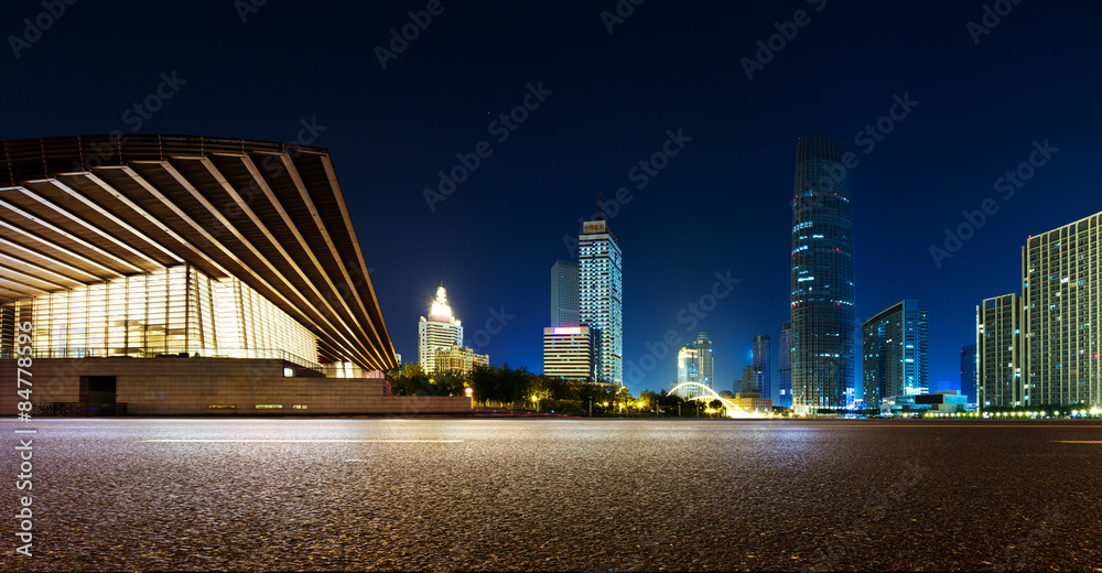 空旷的柏油路和夜晚的现代天际线