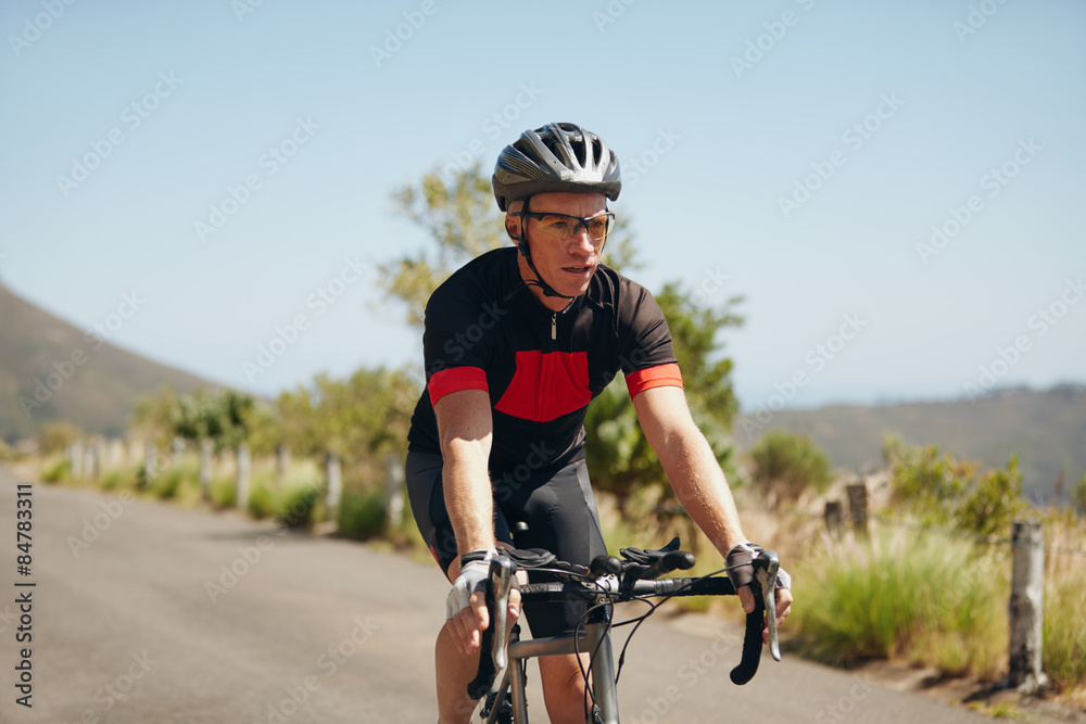 Young man riding bicycle on open road