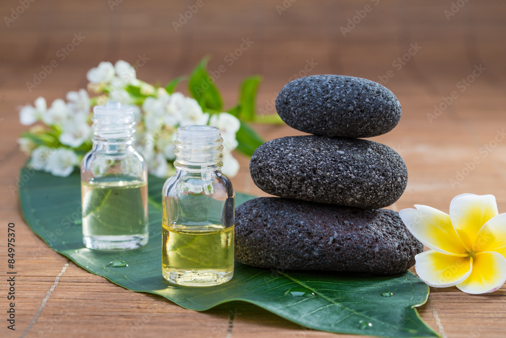 精油，花朵，绿叶上的卵石，模糊背景