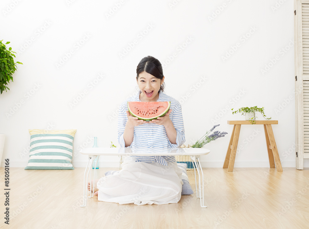 部屋で西瓜を食べる女性