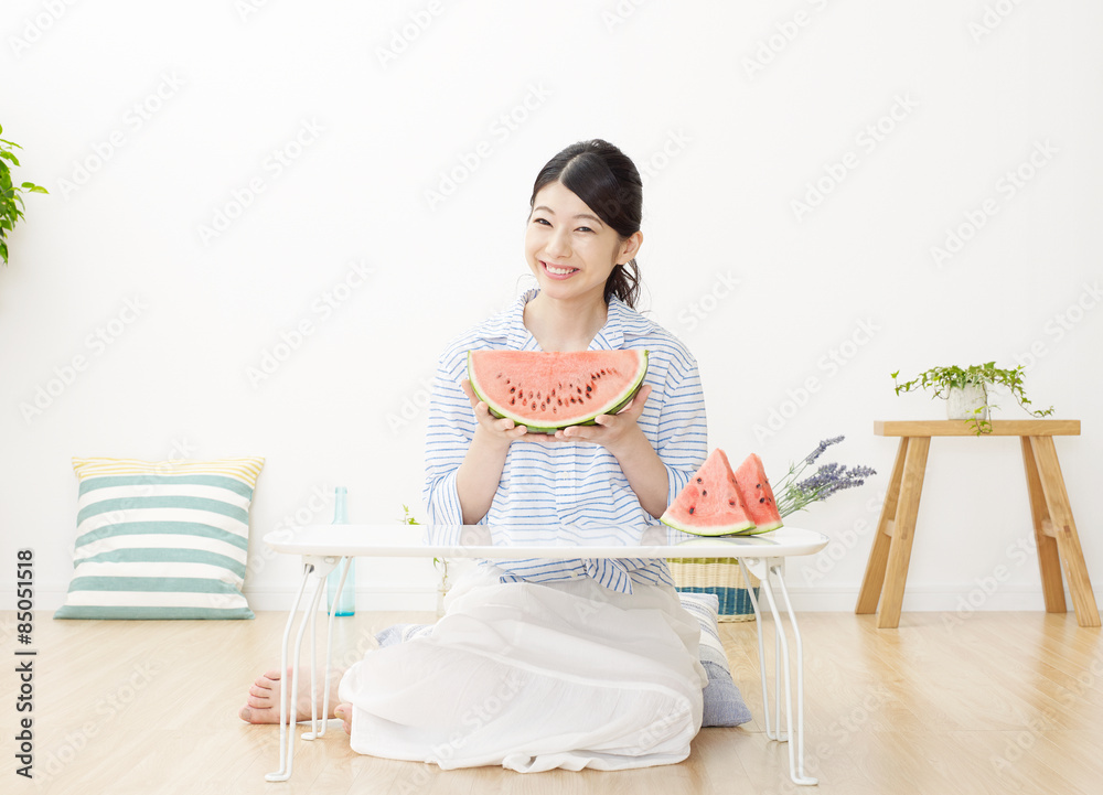 部屋で西瓜を食べる女性