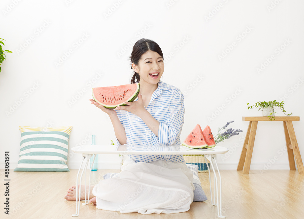 部屋で西瓜を食べる女性