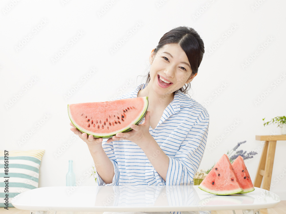 部屋で西瓜を食べる女性