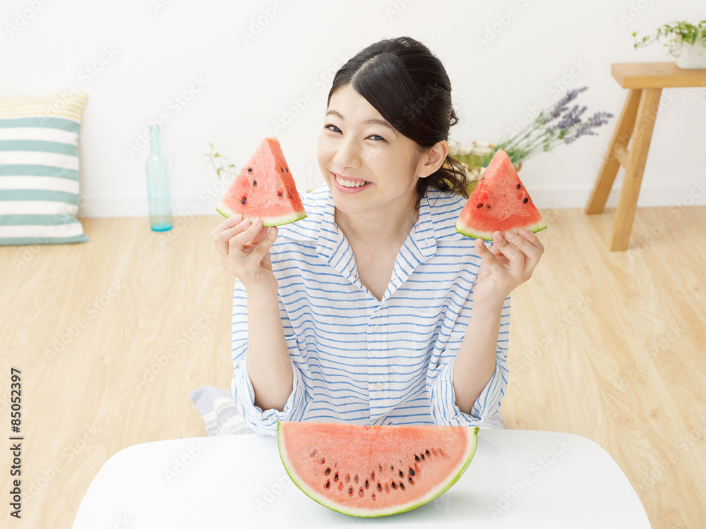 部屋で西瓜を食べる女性