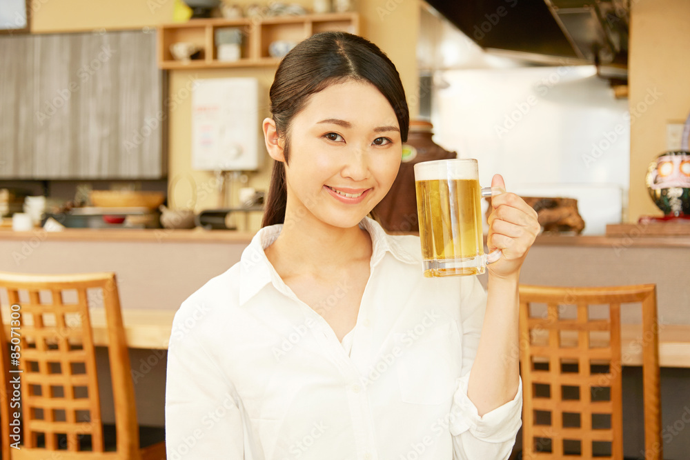 居酒屋でビールを飲む女性