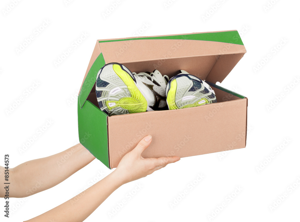 hands holding shoes in a box isolaterd on white background