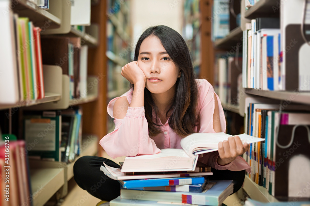 亚洲女人坐在图书馆里发呆