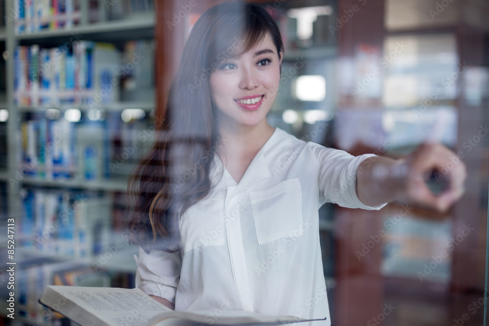 亚洲美女女学生在图书馆触摸草屏