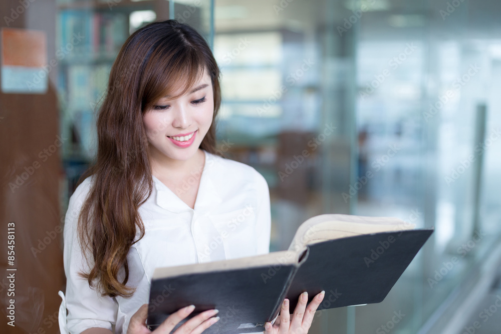 亚洲美女女学生在图书馆拿书