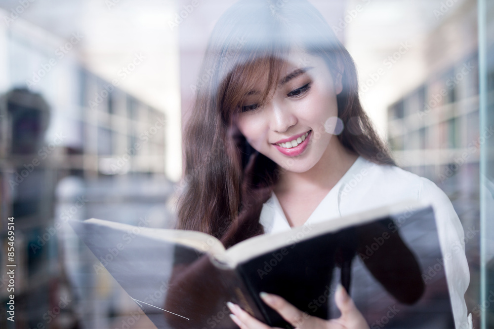 亚洲美女女学生在图书馆拿书