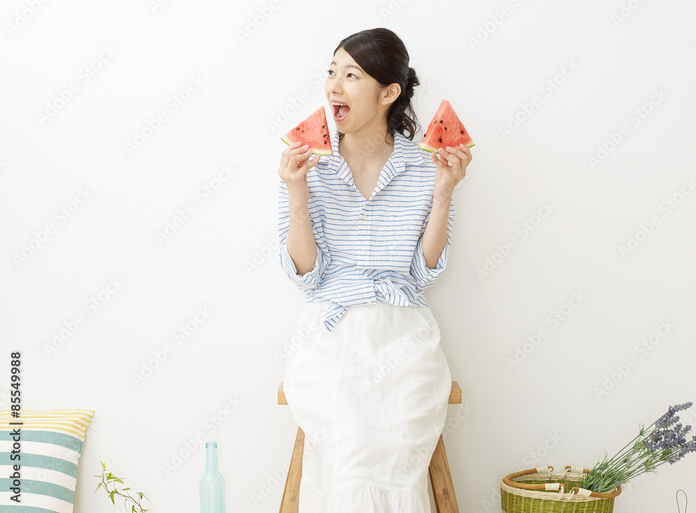 部屋で西瓜を食べる女性