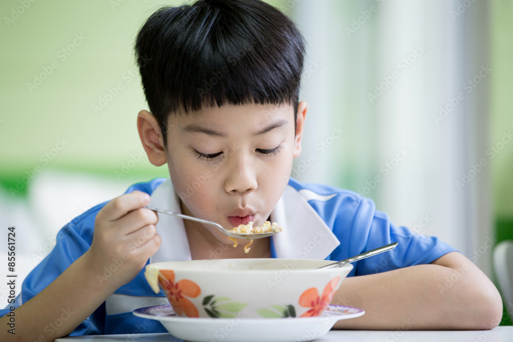 坐在家里吃饭的年轻中国男孩