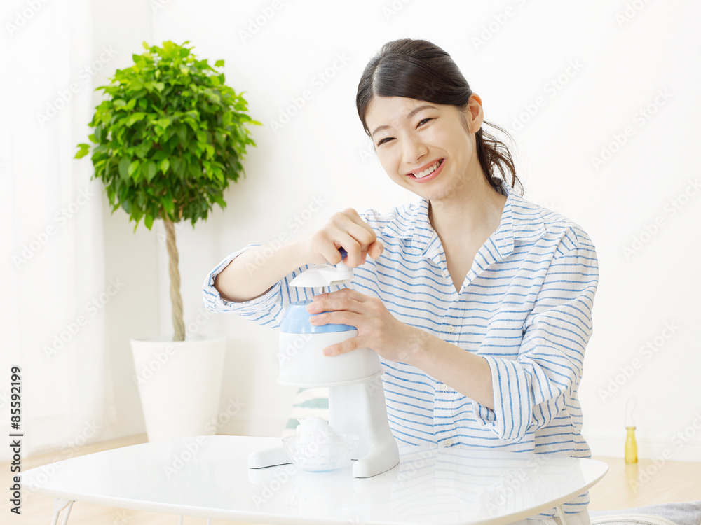 部屋でかき氷を作る女性