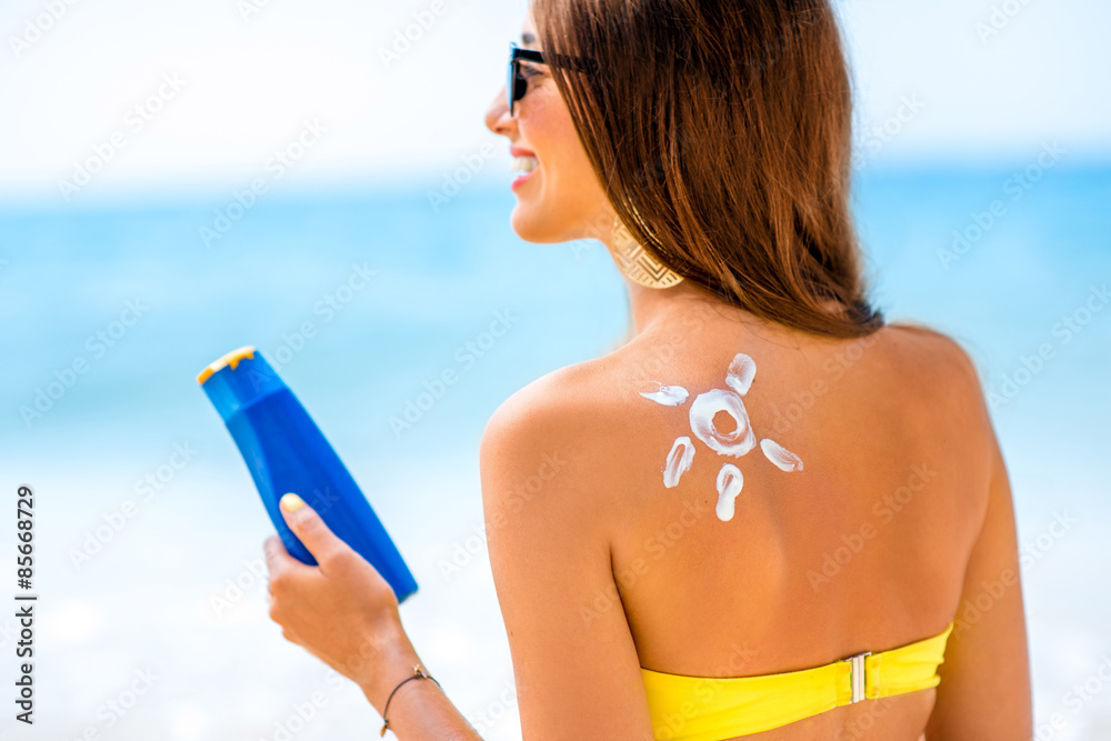 Woman using sun cream on the beach