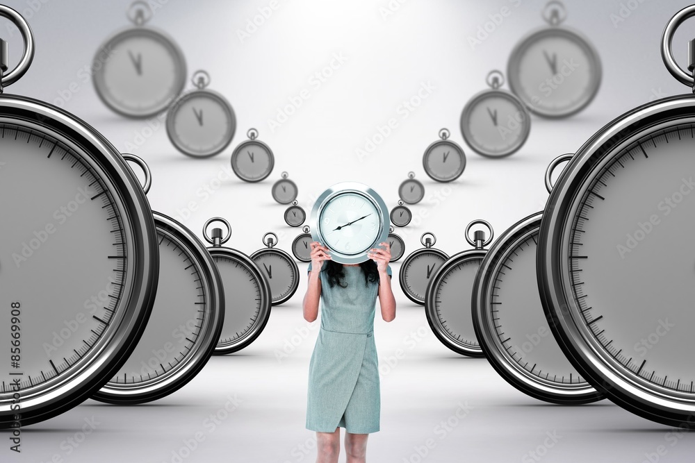 Composite image of businesswoman holding clock