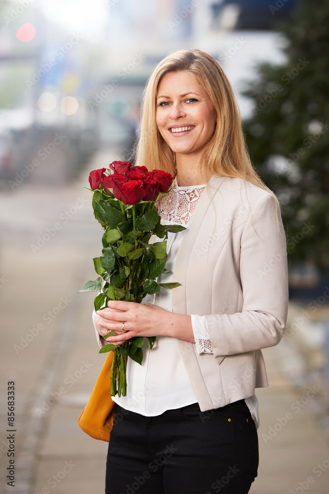 Woman holding a bouquet of red roses