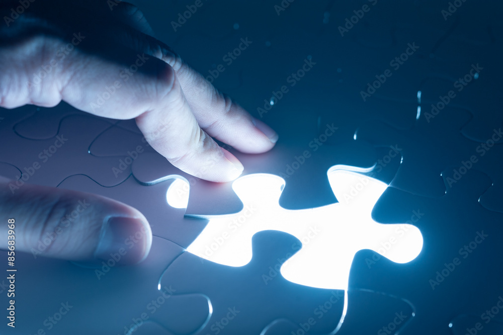 Hand insert jigsaw, conceptual image of business strategy