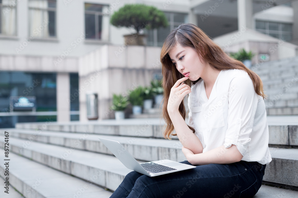 亚洲美女女学生在校园里使用笔记本电脑