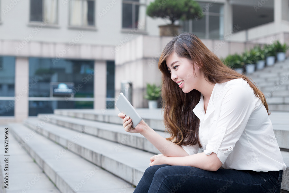 Asian female student using tablet in campus